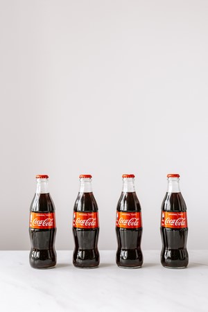 Same bottles of soft drink on white table picture